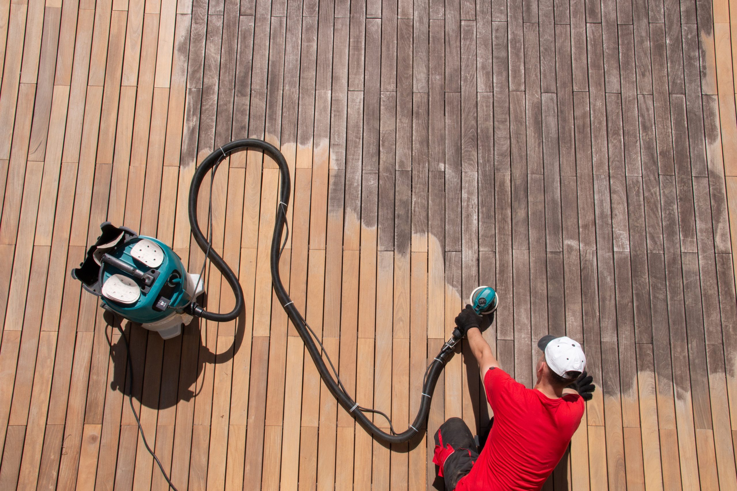 Parquet Floor Sanding in West Kensington shown alongside hardwood deck sanding, with a specialist using a dust-controlled sander to restore weathered timber deck boards.